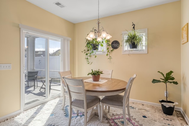 carpeted dining room with a chandelier