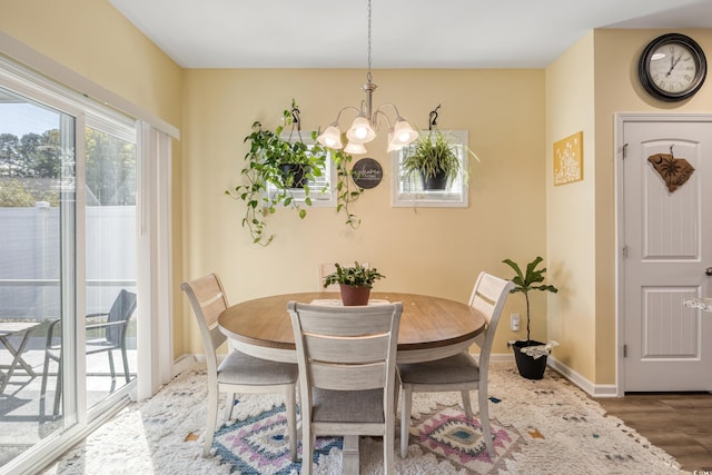 dining area featuring wood-type flooring and a chandelier