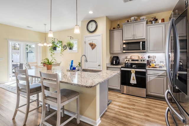 263 Red Maple Loop, Longs, SC 29568 - kitchen featuring a kitchen breakfast bar, gray cabinets, a sink, light wood-style floors, and appliances with stainless steel finishes