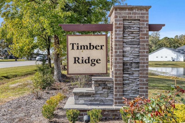 community / neighborhood sign featuring a water view