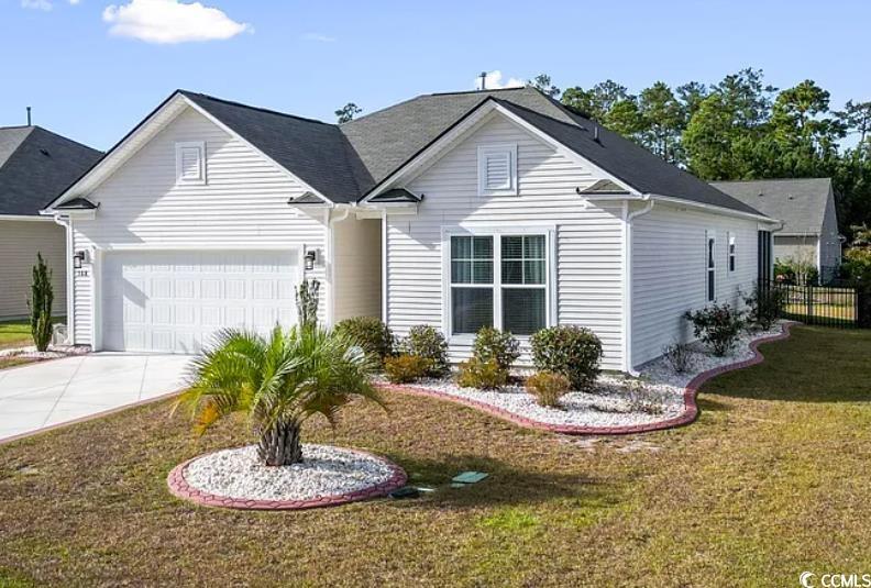 view of front of home with a garage and a front lawn