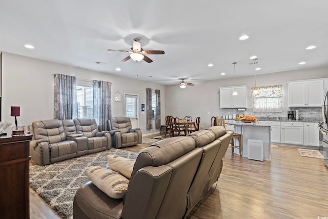 living room featuring light hardwood / wood-style floors and ceiling fan