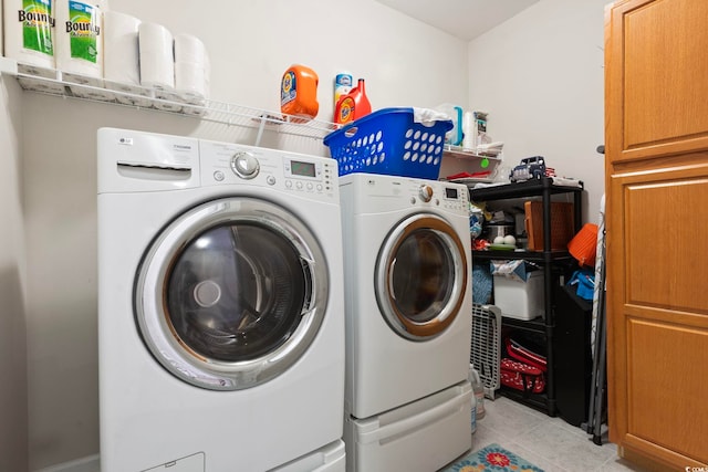 laundry area with light tile patterned flooring, cabinets, and independent washer and dryer