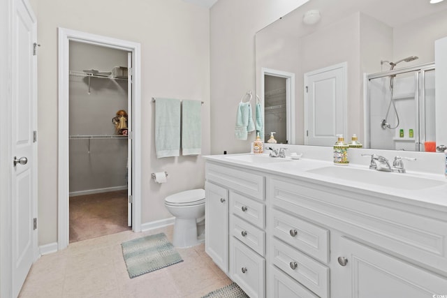 bathroom with tile patterned flooring, vanity, toilet, and walk in shower