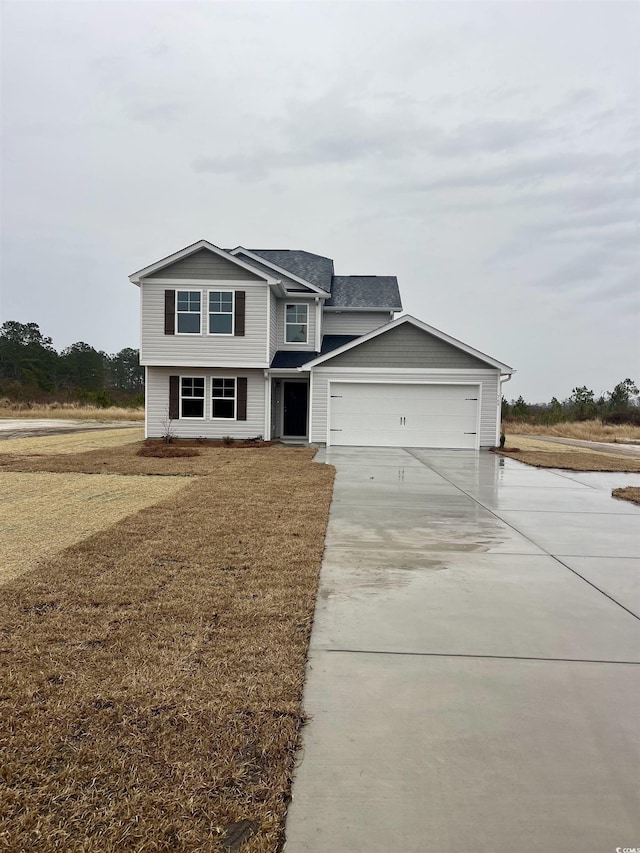 view of front of property with a front yard and a garage