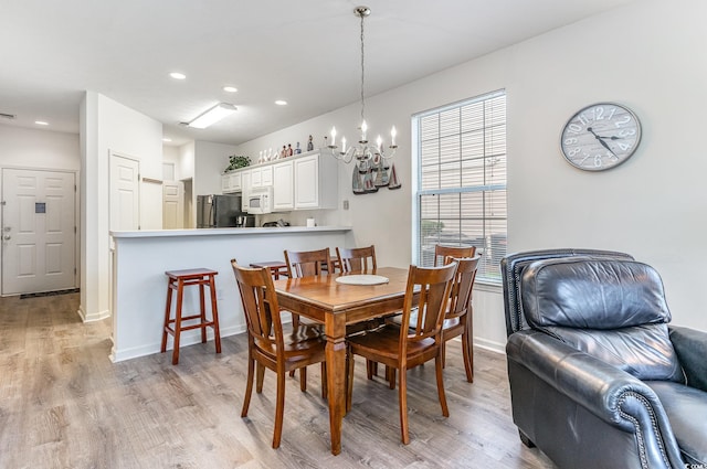 dining space featuring a chandelier and light wood-type flooring