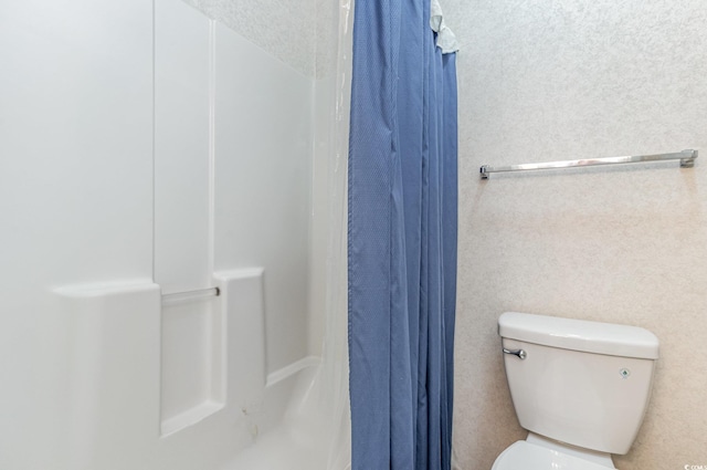 bathroom featuring toilet and walk in shower