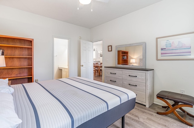 bedroom with ensuite bath, ceiling fan, and light hardwood / wood-style flooring