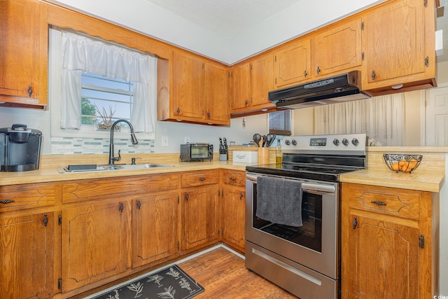 kitchen with light hardwood / wood-style flooring, sink, and electric stove