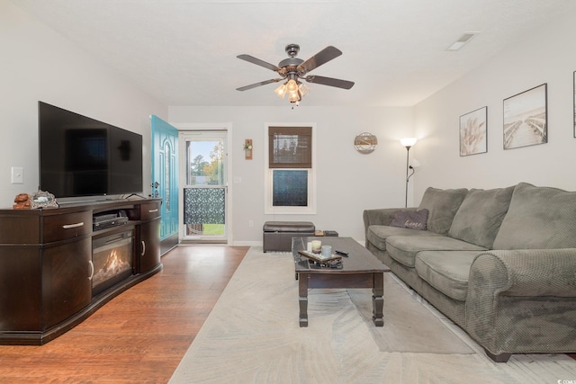 living room featuring wood-type flooring and ceiling fan