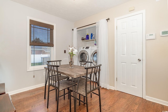 dining area featuring washer and dryer, a textured ceiling, and dark hardwood / wood-style flooring