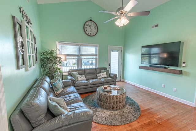 living room with hardwood / wood-style floors, high vaulted ceiling, and ceiling fan