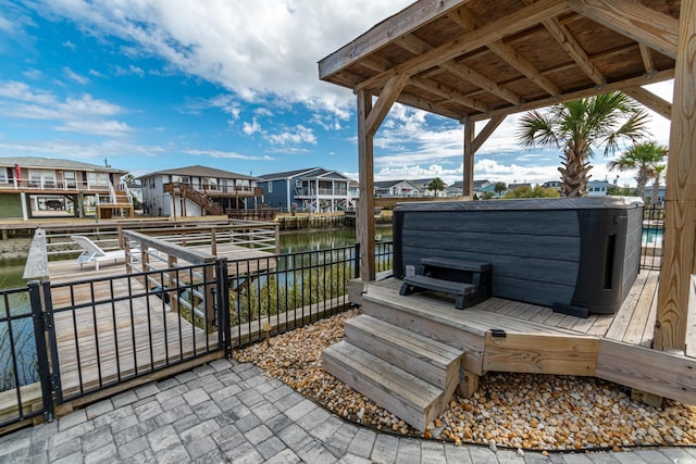 exterior space with a water view and a hot tub