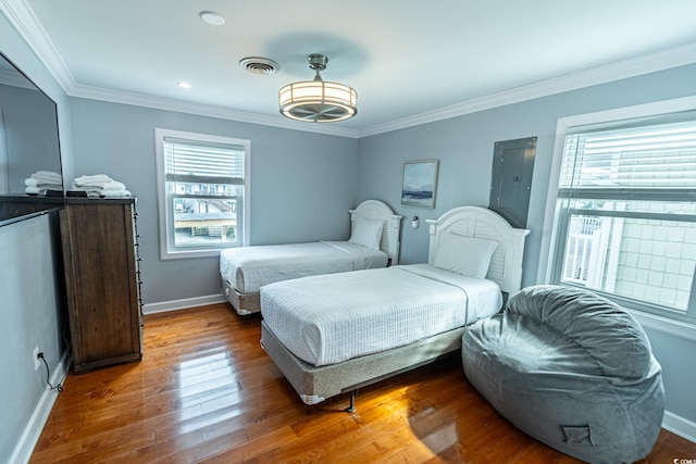 bedroom featuring crown molding, multiple windows, and hardwood / wood-style flooring