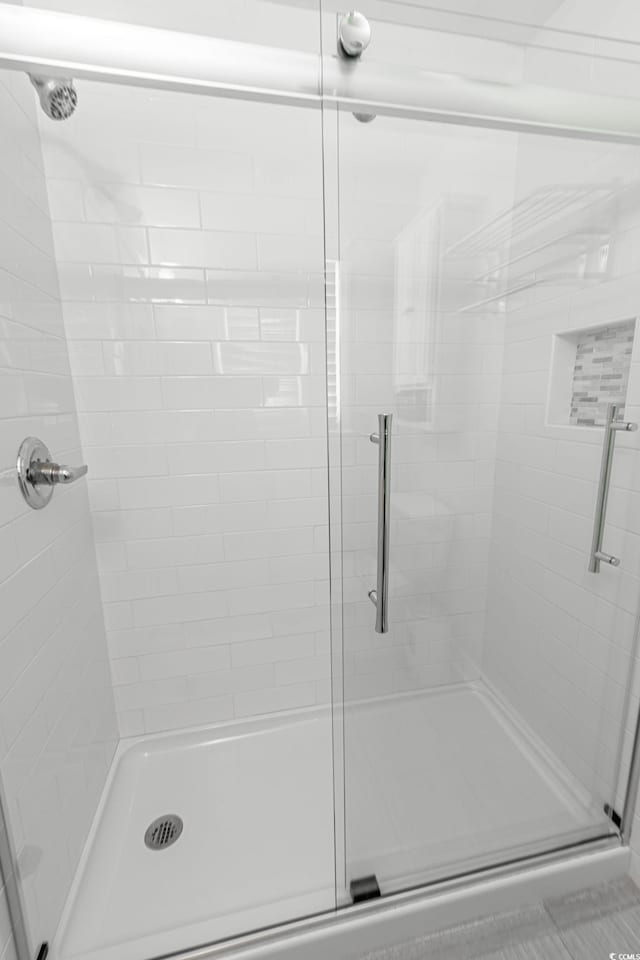 bathroom with a shower with door