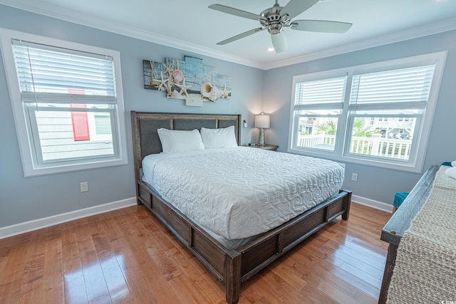 bedroom with multiple windows, hardwood / wood-style floors, crown molding, and ceiling fan