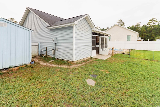 back of house with a yard and a sunroom