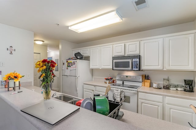 kitchen featuring white cabinets and white appliances