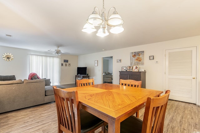 dining room with light wood-type flooring and ceiling fan with notable chandelier