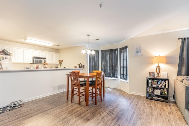 dining room featuring light hardwood / wood-style floors and a chandelier