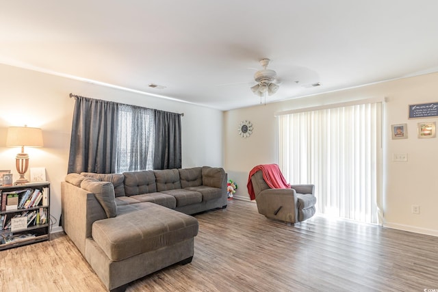 living room featuring wood-type flooring and ceiling fan