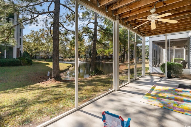 unfurnished sunroom with a water view and ceiling fan