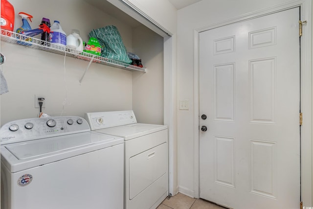 laundry room featuring washing machine and dryer and light tile patterned floors