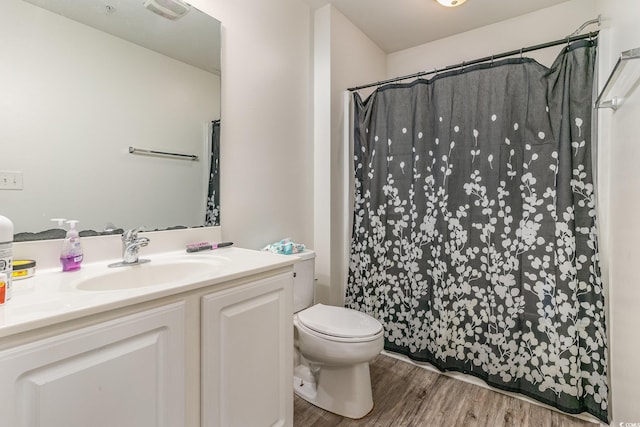 bathroom with vanity, hardwood / wood-style floors, a shower with curtain, and toilet