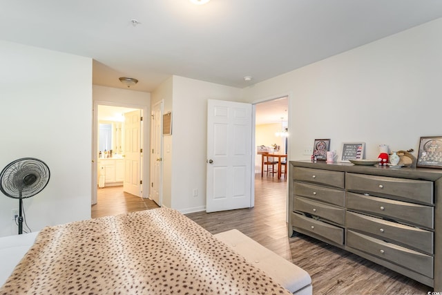 bedroom with hardwood / wood-style floors and ensuite bathroom