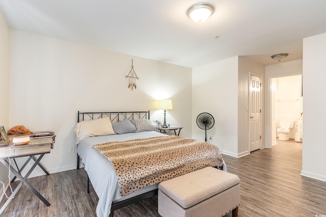 bedroom with hardwood / wood-style floors and ensuite bathroom