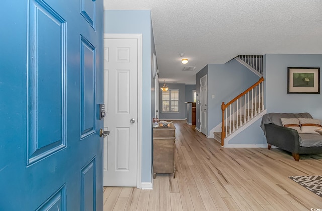 entryway featuring a textured ceiling and light wood-type flooring