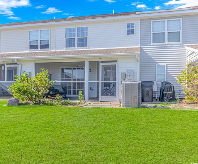 back of property with a yard and central AC unit