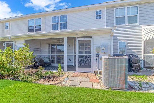 rear view of house featuring central AC and a yard