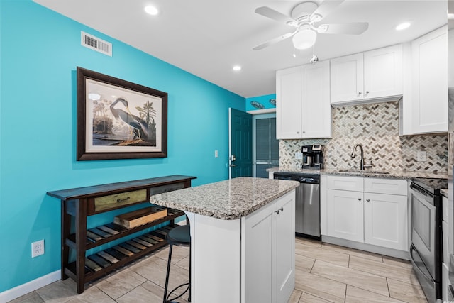 5601 N Ocean Blvd Unit C-202, Myrtle Beach, SC 29577 - kitchen with appliances with stainless steel finishes, a sink, a kitchen island, decorative backsplash, and white cabinets