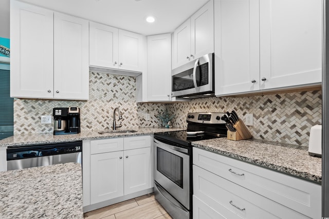 5601 N Ocean Blvd Unit C-202, Myrtle Beach, SC 29577 - kitchen with stainless steel appliances, a sink, white cabinets, tasteful backsplash, and recessed lighting
