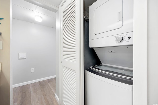 washroom featuring light wood-type flooring and stacked washing maching and dryer