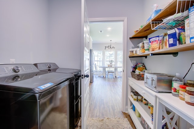 laundry area featuring separate washer and dryer and light hardwood / wood-style flooring