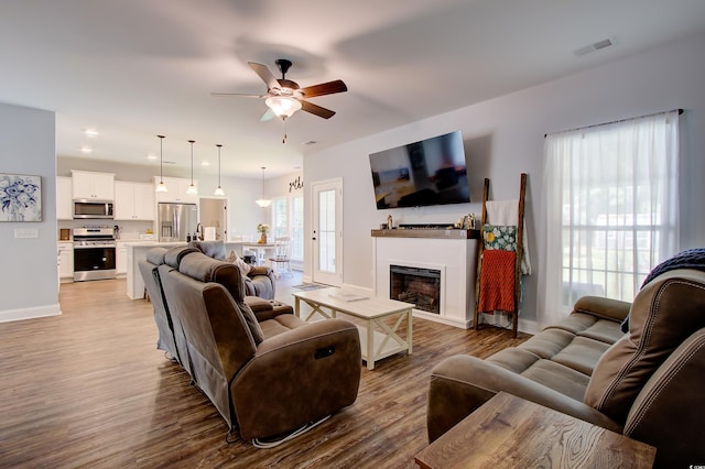 living room with ceiling fan and light hardwood / wood-style floors