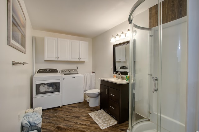 bathroom with walk in shower, vanity, hardwood / wood-style flooring, independent washer and dryer, and toilet