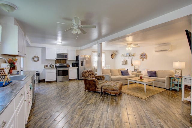 living room featuring ceiling fan, a wall mounted AC, and sink