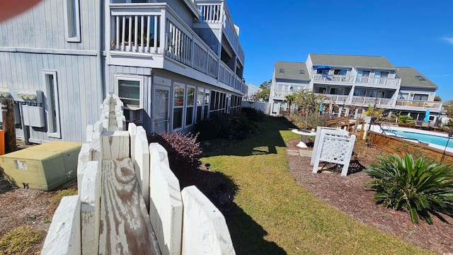 exterior space with a fenced in pool and a balcony