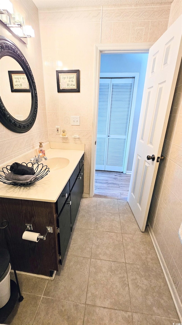 bathroom featuring vanity, tile patterned floors, and tile walls