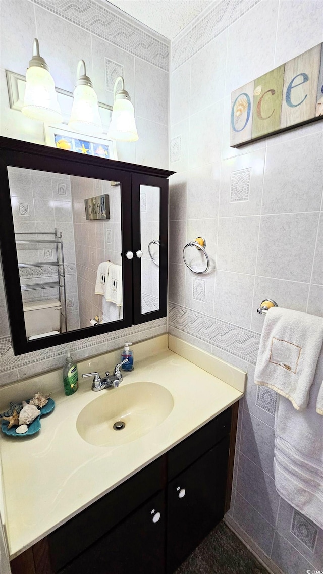 bathroom with tile walls, vanity, and a textured ceiling