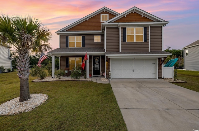 view of front of home with covered porch, a garage, and a lawn