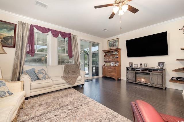 living room featuring dark hardwood / wood-style flooring, crown molding, and plenty of natural light