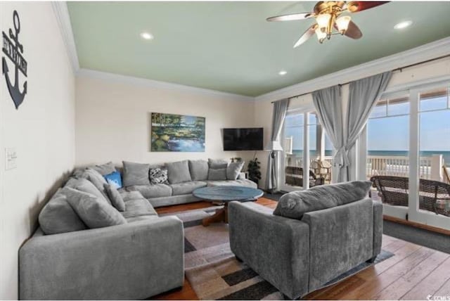 living room with crown molding, dark hardwood / wood-style floors, and ceiling fan