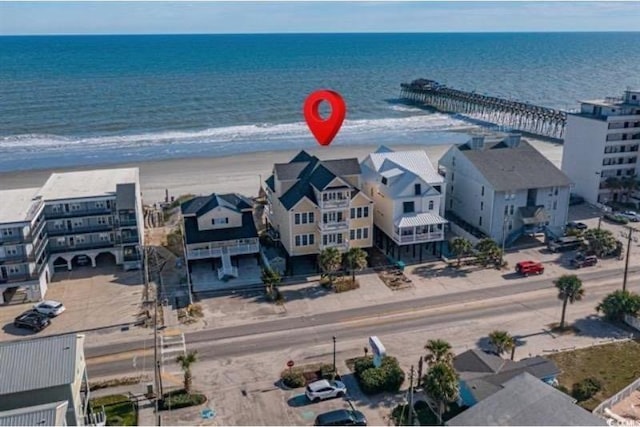 birds eye view of property featuring a water view and a beach view