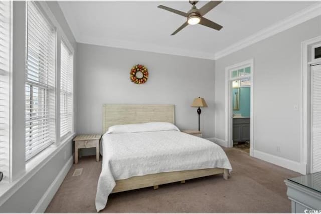 carpeted bedroom with ceiling fan, crown molding, multiple windows, and ensuite bath