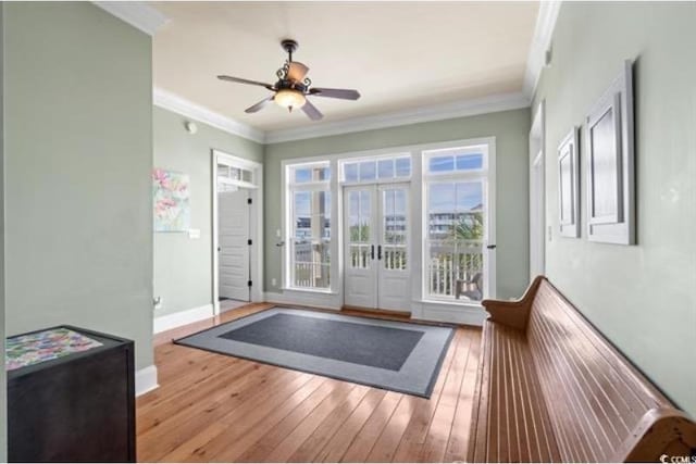 doorway featuring ornamental molding, light wood-type flooring, and ceiling fan