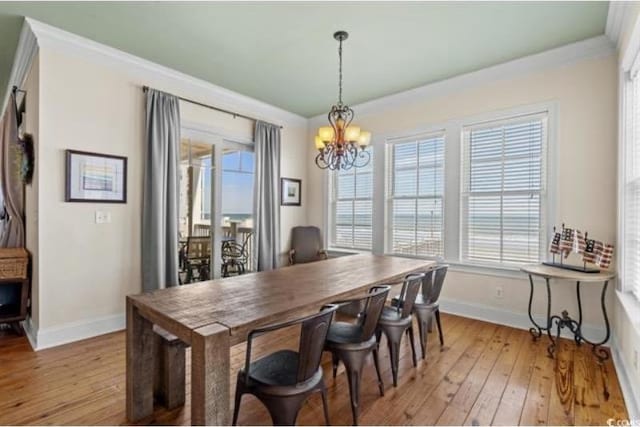 dining room featuring light hardwood / wood-style floors, an inviting chandelier, and crown molding